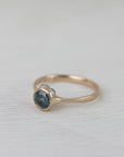 Gold ring with a blue gemstone on a light fabric background