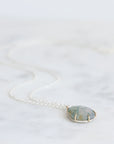 Necklace with a green stone pendant on a white background