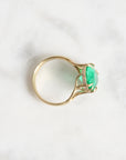 Large green gemstone ring with a diamond halo and branchy setting