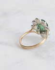 Ring with a green gemstone on a light gray background