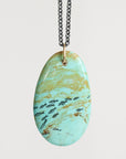 Turquoise marbled pendant necklace on a light gray background
