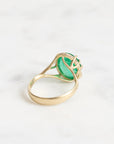 Large green gemstone ring with a diamond halo and branchy setting