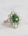 Silver ring with a green gemstone on a white background