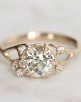 Gold ring with a diamond on a light gray background