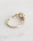 Gold ring with a diamond on a light gray background