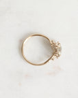 Gold ring with a diamond on a light marble background