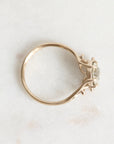Gold ring with a diamond on a light marble background
