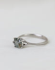 Silver ring with a gemstone on a light gray background
