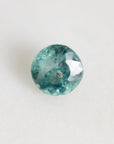 Greenish blue round montana sapphire with swirling inclusions