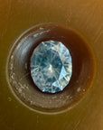 Blue gemstone in a brown circular setting