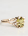 Gold ring with a green gemstone on a light gray background