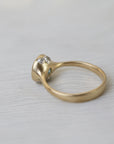 Gold ring with gemstones on a light fabric background