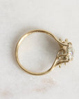 Gold ring with a diamond on a light marble background