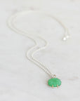 Necklace with a green pendant on a light gray background