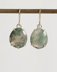 Pair of green stone earrings on a white background