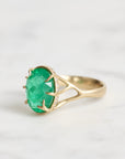 Large green gemstone ring with a diamond halo and branchy setting
