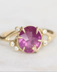 Gold ring with a purple gemstone on a light gray background
