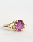 Gold ring with a pink gemstone on a white background