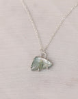 Necklace with a green crystal pendant on a light gray background