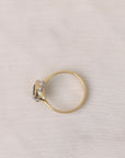 Gold ring with a diamond on a light gray fabric background
