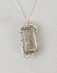 Necklace with a clear stone pendant on a light gray background