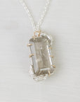 Necklace with a light gemstone pendant on a white background