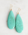 Teal teardrop earrings on a light background