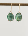 Green gemstone earrings on a white background