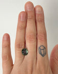 Green gemstone on hand with tattoo