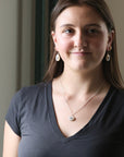Woman wearing a dark gray shirt with a neutral background