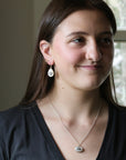 Woman wearing earrings and a necklace indoors