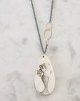Necklace with a mermaid pendant on a marble surface