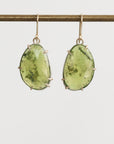 Green gemstone earrings on a white background