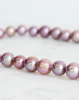 Pink pearl strand with lavender thread and gold barnacles
