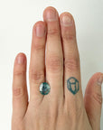 Hand with a ring featuring a green gemstone on a white background