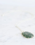 Necklace with a green pendant on a white background