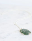 Necklace with a green pendant on a white background