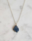 Necklace with a blue pendant on a marble surface