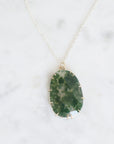 Necklace with a green stone pendant on a white background