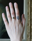 Hand with a ring and tattoo, blurred background