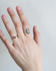 Hand with a ring and tattoo on a plain background