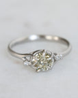 Diamond ring with a heart-shaped center stone on a light gray background