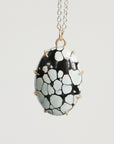 Necklace with a black and white patterned pendant on a light gray background