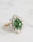 Silver ring with a green gemstone on a white background