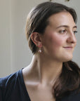 Woman wearing earrings with a neutral background