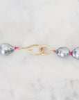 Pearl necklace with a gold clasp on a marble background