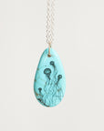 Teardrop-shaped pendant with jellyfish design on a light blue background