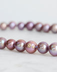 Pink pearl strand with lavender thread and gold barnacles
