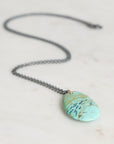 Necklace with a turquoise stone pendant on a light background