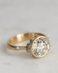 Gold ring with a large diamond on a light gray background